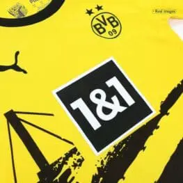 a yellow shirt with black and white logo