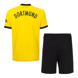 a yellow shirt and black shorts