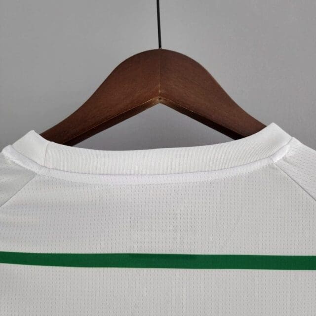 a white shirt with green stripes on a wooden swinger