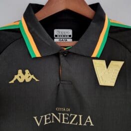 a black shirt with gold and green stripes